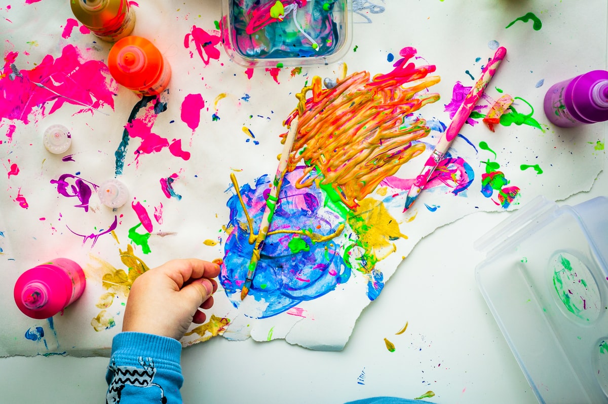 A child creating a colourful painting